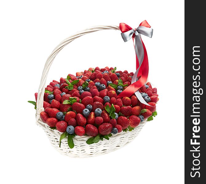Large Wicker Basket Filled With Ripe Strawberries And Blueberries On A White Background