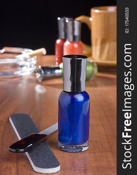 Nail accessories placed on a coffee table in front of a cup of coffee and an ashtray. Nail accessories placed on a coffee table in front of a cup of coffee and an ashtray.