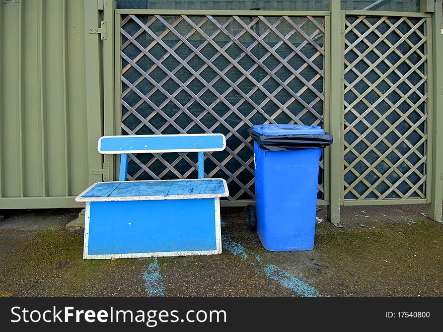 A blue bin for trash. A blue bin for trash
