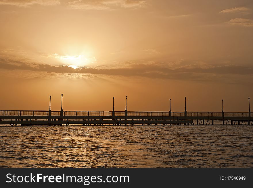 Dawn sunrise over a tropical ocean and pier. Dawn sunrise over a tropical ocean and pier