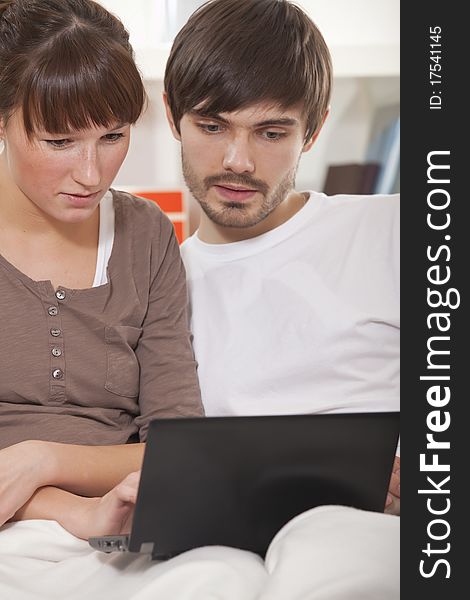 Young couple with laptop computer sitting on sofa. Young couple with laptop computer sitting on sofa