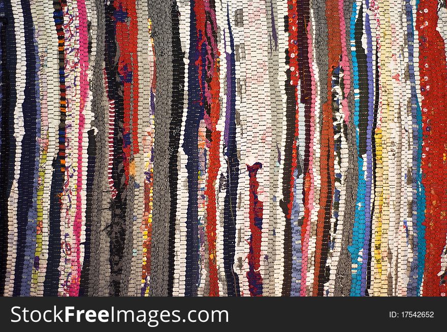 Multicolored rug, made of different pieces. Frontally, a fragment, closeup.