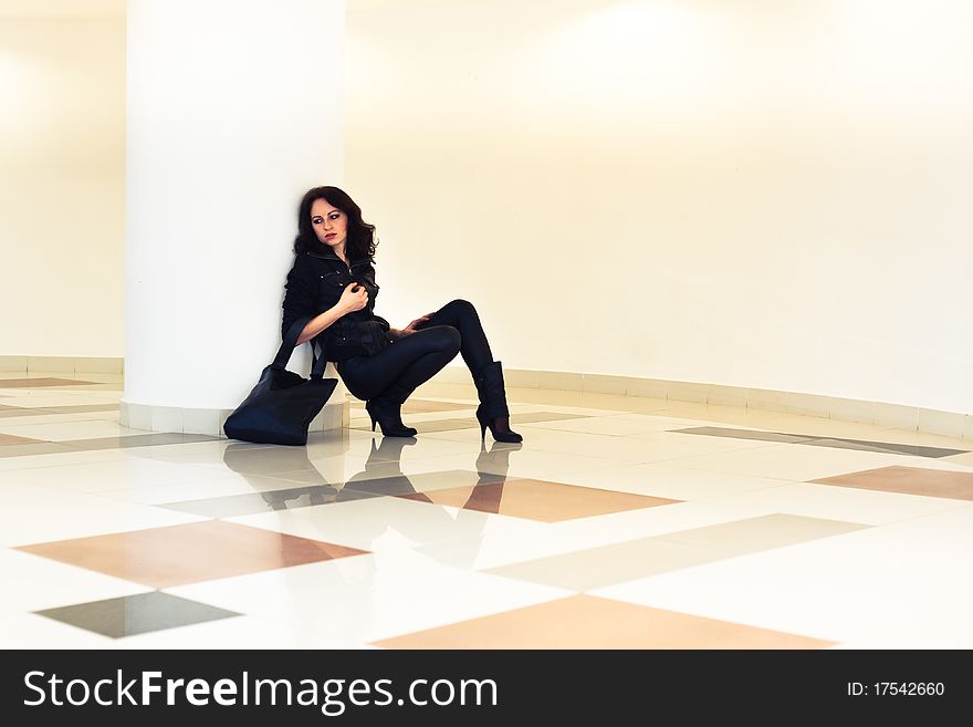 Woman with a bag sitting with his elbows, look distance