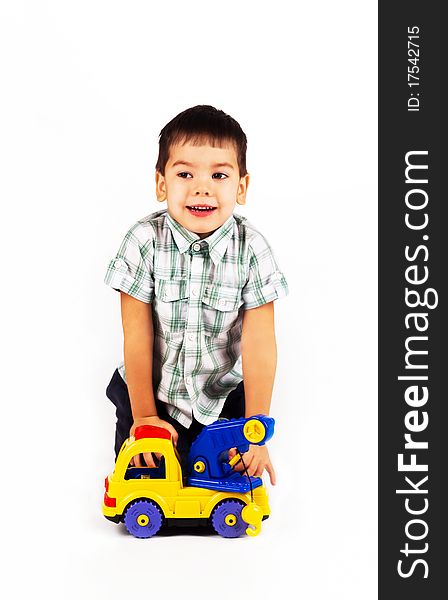 Happy little baby boy playing with cars and toys.