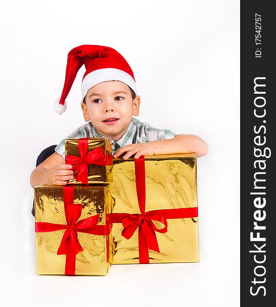 Happy little boy in Santa hat with a bunch of gifts, holiday Christmas, New Year