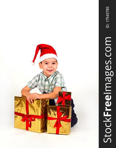 Boy in Santa hat with a bunch of gifts