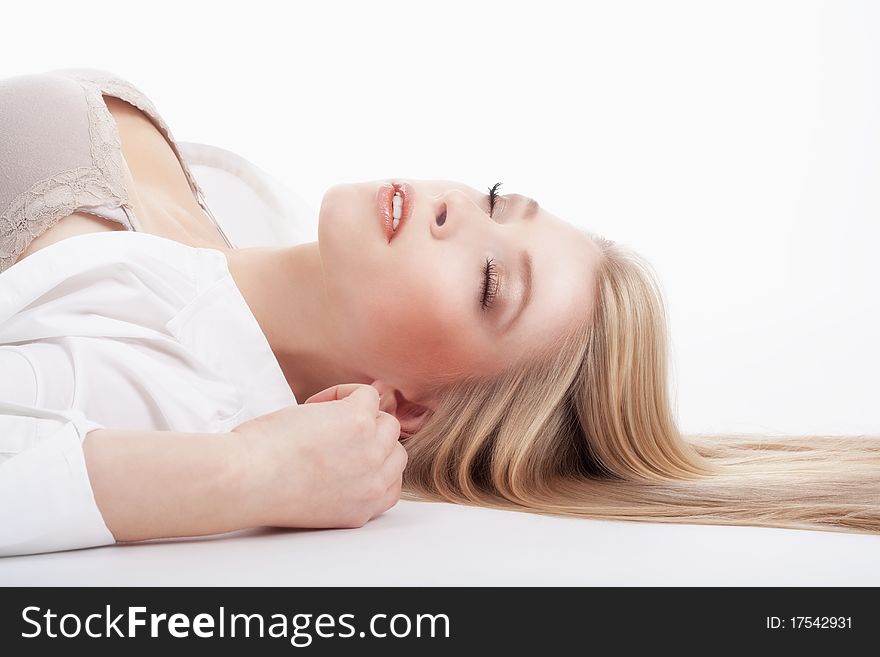 Beautiful young woman lying down, eyes closed, dreaming - isolated on white. Beautiful young woman lying down, eyes closed, dreaming - isolated on white