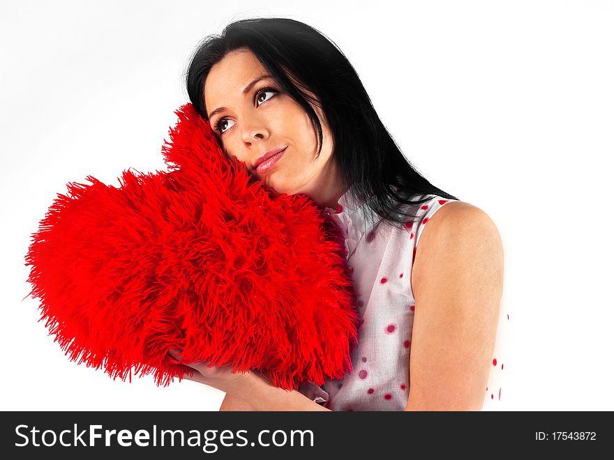 Young beautiful brunette girl hugs a big soft heart. Feast of St. Valentine's Day. Young beautiful brunette girl hugs a big soft heart. Feast of St. Valentine's Day.