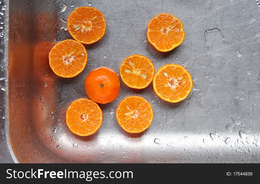 Cut oranges in a kitchen sink ready to be squeezed. Cut oranges in a kitchen sink ready to be squeezed