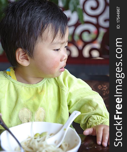 A cute baby is eating in a restaurant. A cute baby is eating in a restaurant.