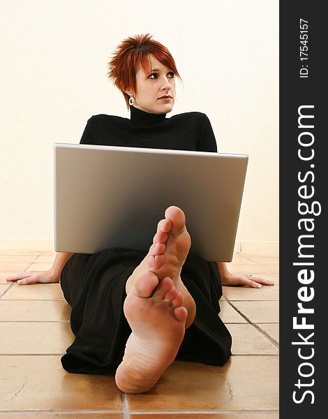 Attractive 30 year old woman with concerned expression and open laptop on floor. Attractive 30 year old woman with concerned expression and open laptop on floor.