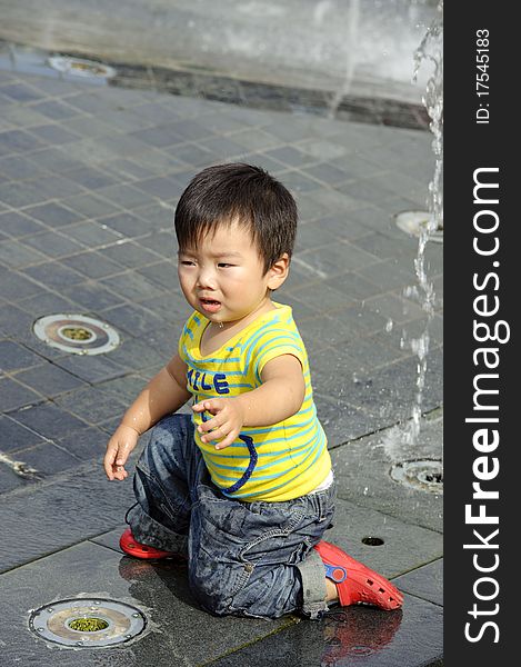 A cute baby is playing fountain