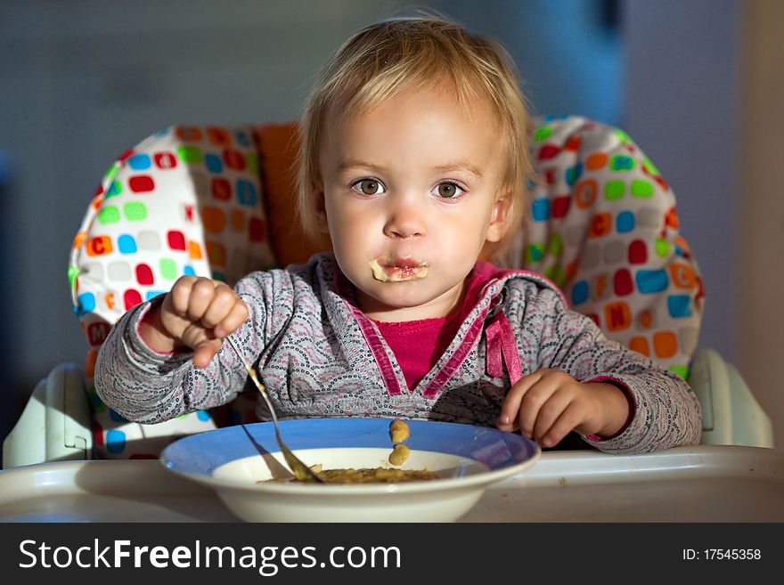 Little girl eats porridge