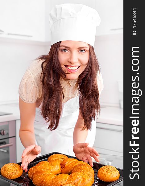 Beautiful young woman baking bread in the kitchen