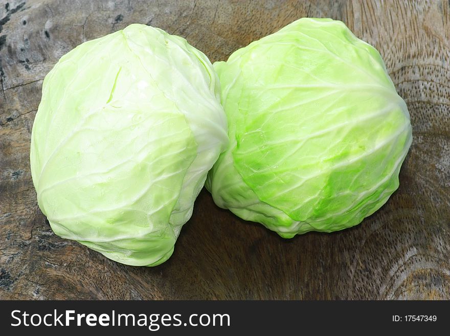 Green cabbage isolated on wood background