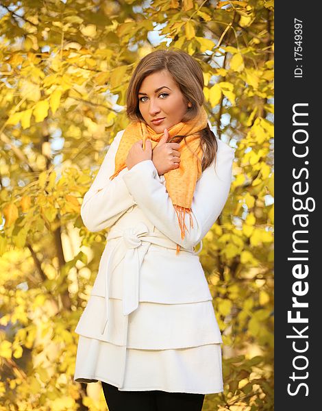 Attractive young woman in white coat outside. Attractive young woman in white coat outside