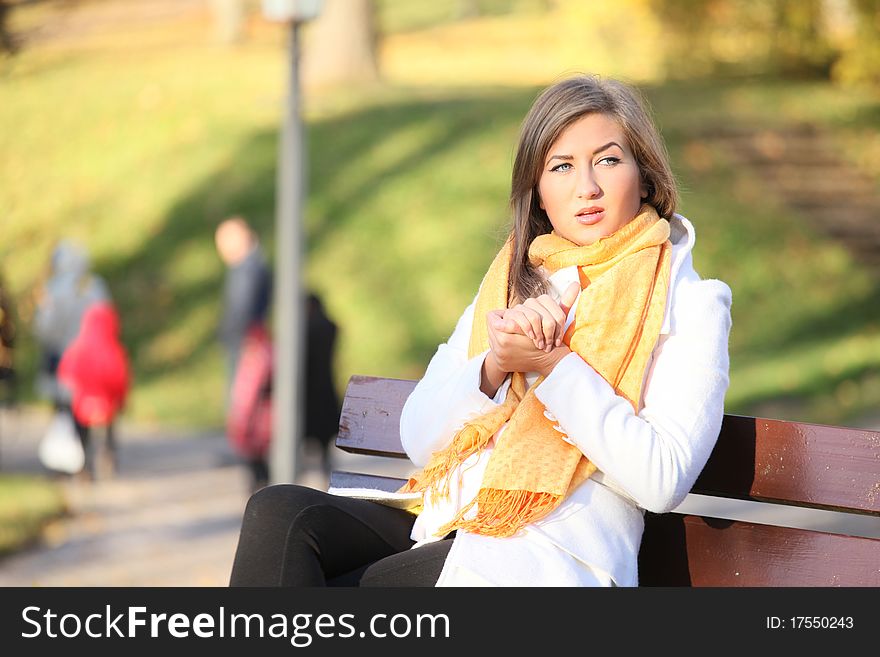 Woman warming her hands in autumn park