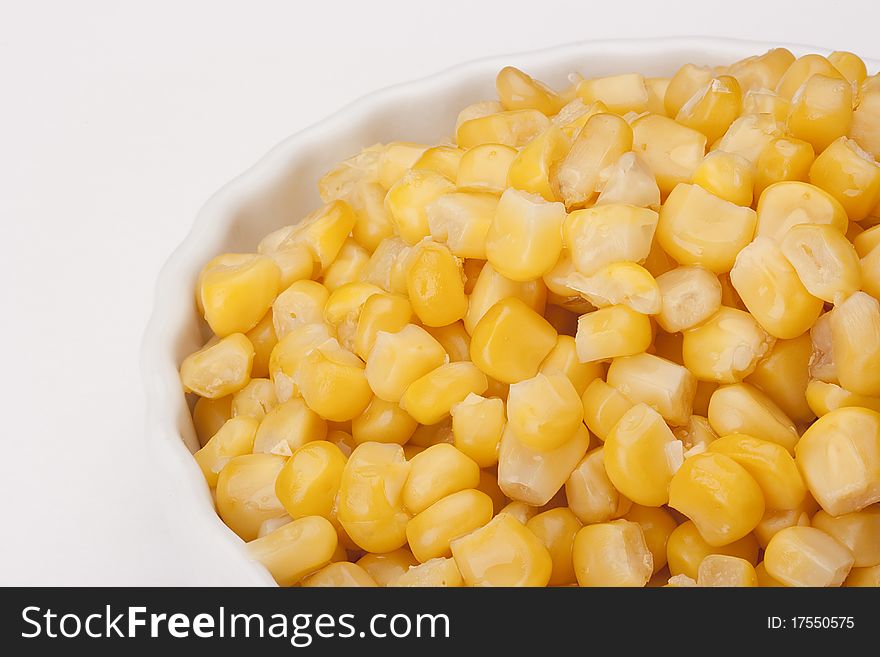 Canned corn in a circular plate on a white background.