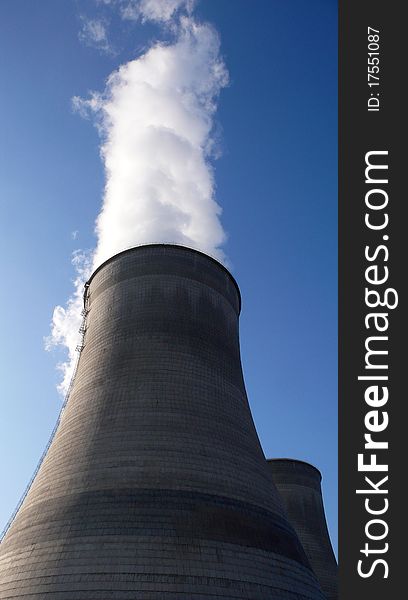 View of the big water towers in a heat power plant with blue skies as backgrounds