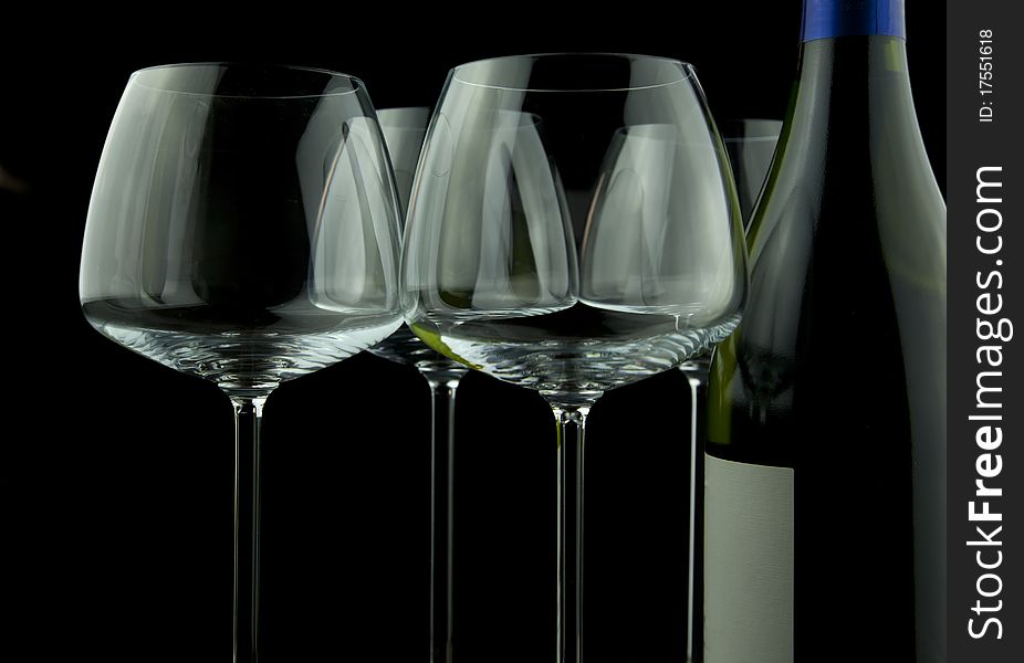 Wine glasses and wine bottle isolated over black background. Wine glasses and wine bottle isolated over black background