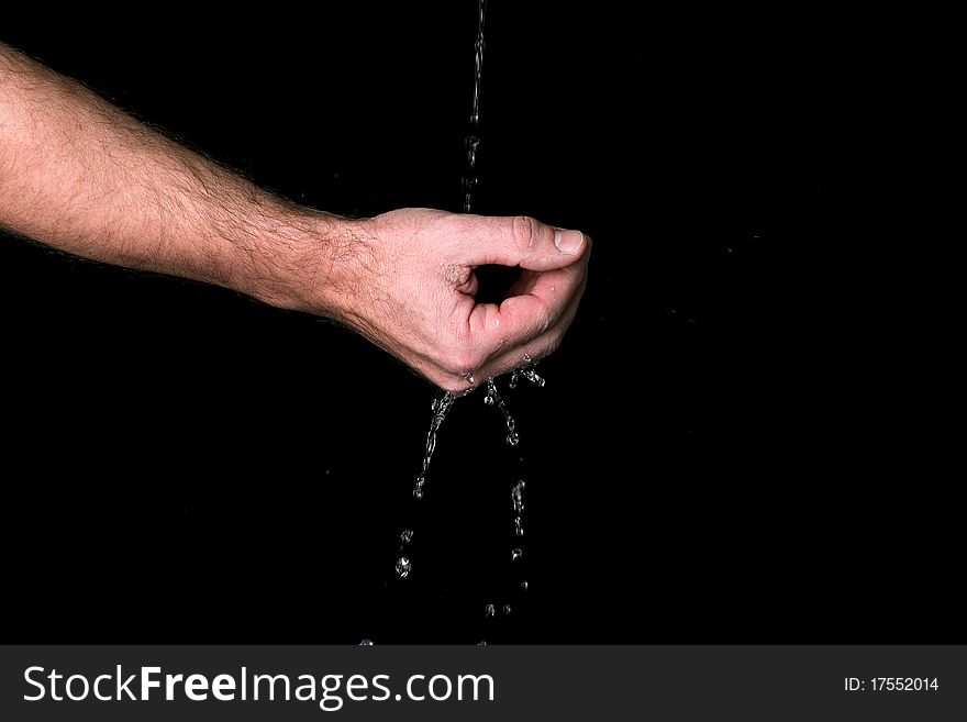 Water runs trough the fingers - against black background