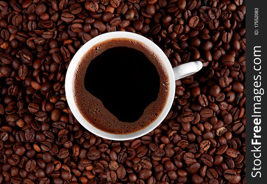 Cup of black coffee, isolated on roasted coffee beans