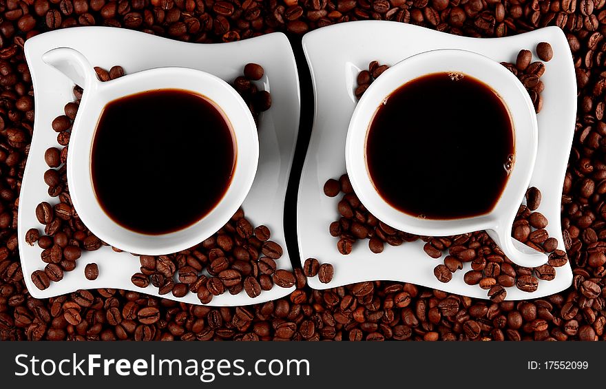 Two cups of coffee, isolated on roasted coffee beans. Two cups of coffee, isolated on roasted coffee beans
