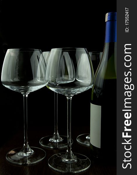 Wine glasses and wine bottle isolated over black background. Wine glasses and wine bottle isolated over black background