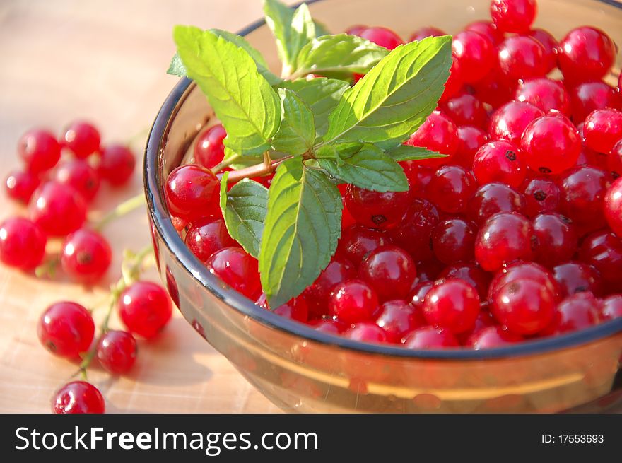 Bowl of redcurrant fruit on wooden background