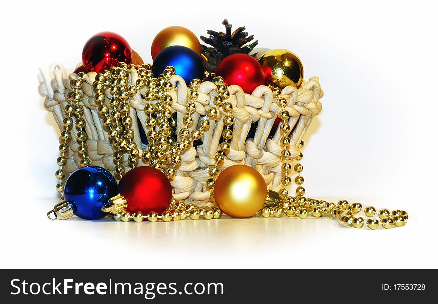 A basket with Christmas-tree decorations and pine cones