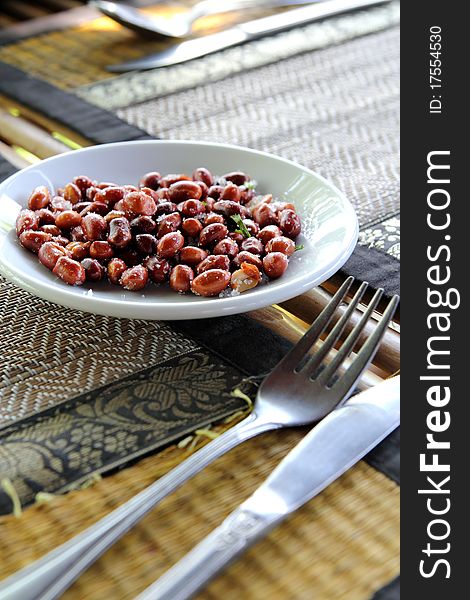 Peanuts on dining table as starter with knife and fork