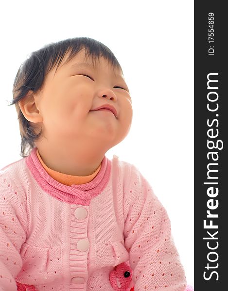 A smiling Asian baby girl sitting on the bed. A smiling Asian baby girl sitting on the bed