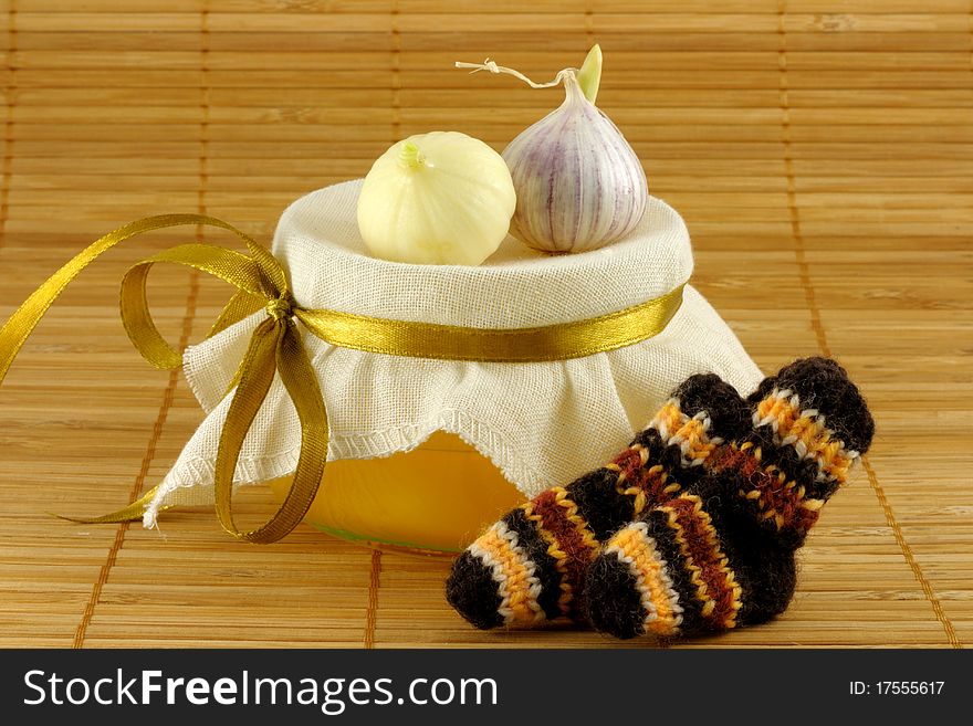 Honey, garlic, warm socks on a brown background