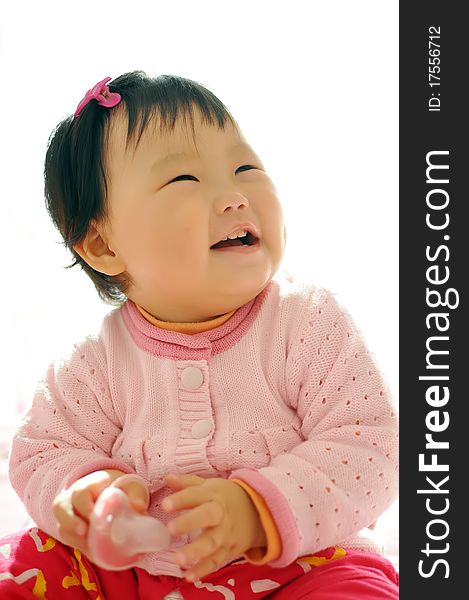 A Asian baby girl sitting on the bed