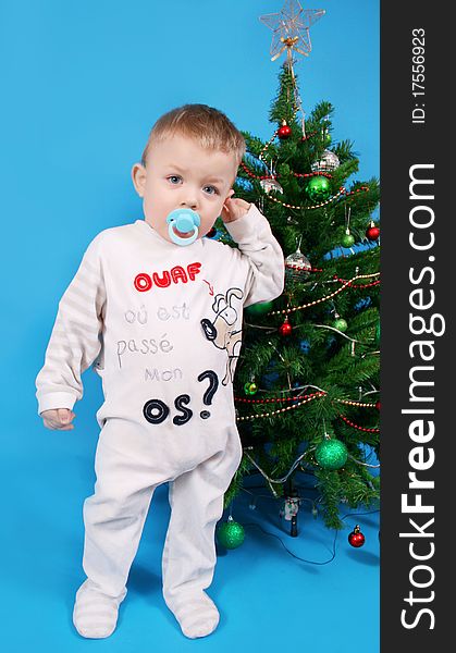 Boy near the Christmas tree on a blue background