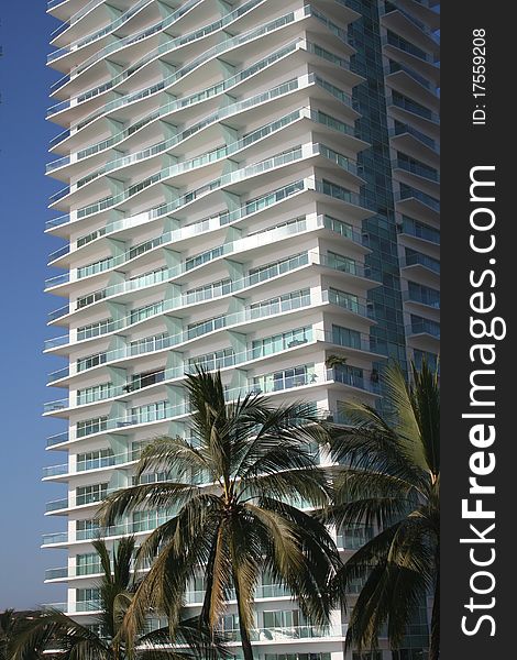 Highrise of vacation condominiums in tropical location with palm trees. Highrise of vacation condominiums in tropical location with palm trees.