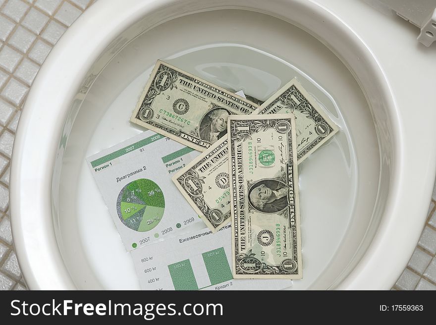 Dollars getting ready to be flushed down the toilet. Photo for payments, finance, taxes, wasteful spending and any other financial inference