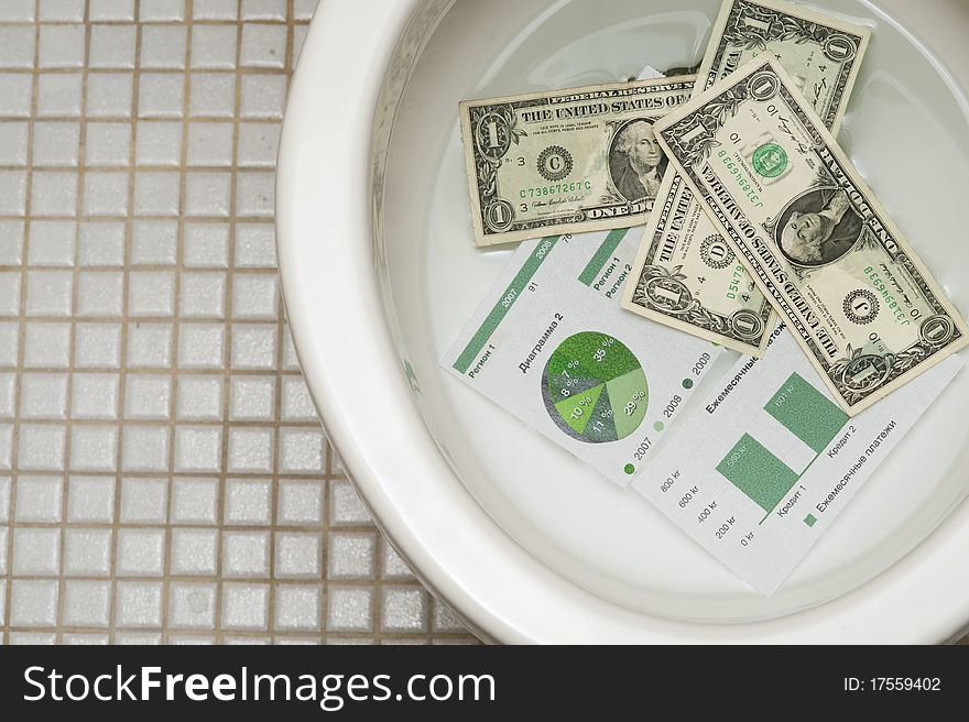 Dollars getting ready to be flushed down the toilet. Photo for payments, finance, taxes, wasteful spending and any other financial inference