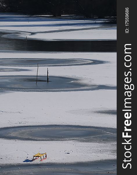 Small frozen river with sledge on snow and ice