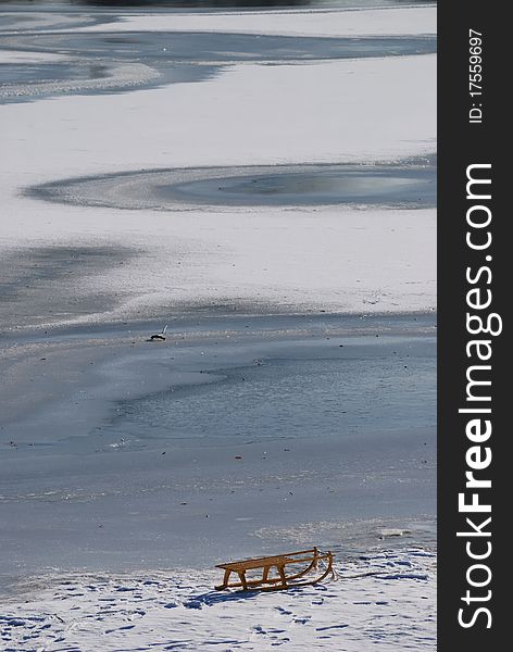 Small frozen river with sledge on snow and ice