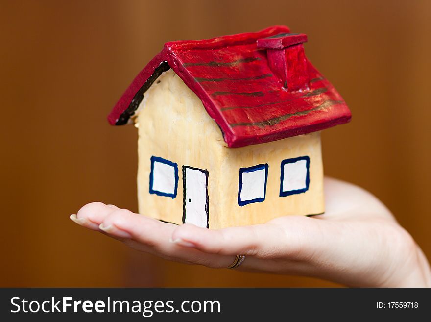 A woman holding a house in her hand