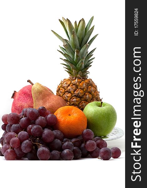 Dish with different fruit: pineapple, grapes, a pear, a tangerine, an apple on a white background separately. Dish with different fruit: pineapple, grapes, a pear, a tangerine, an apple on a white background separately