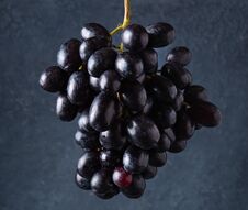 A Cluster Of Juicy Black Grapes   On A Dark Gray Background Royalty Free Stock Photos
