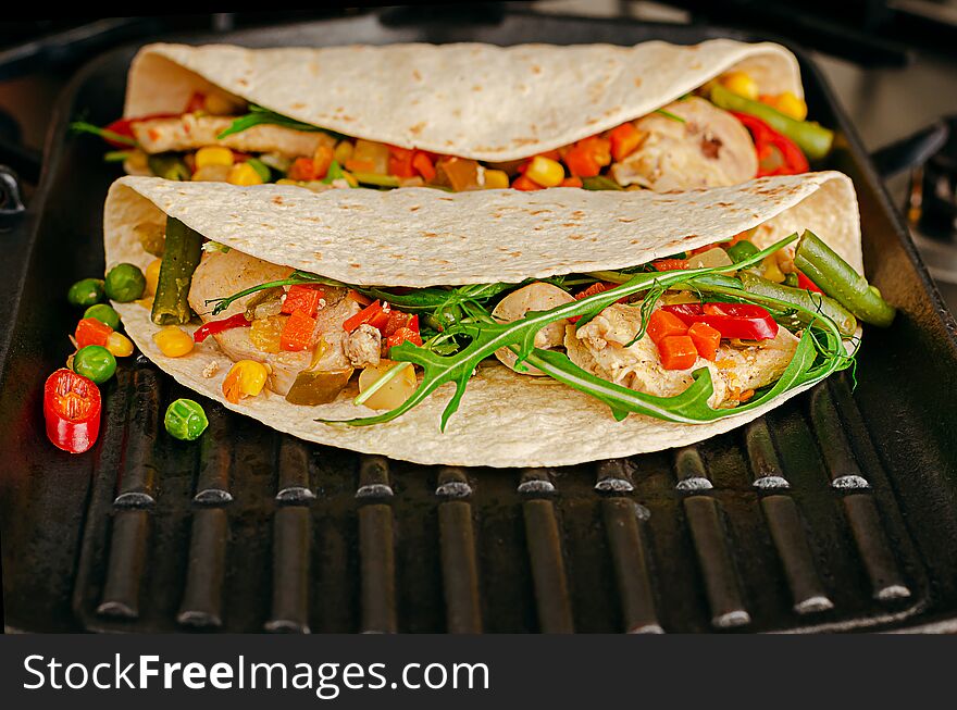 Delicious Mexican food. Tacos with vegetables and chicken on grill pan. Copy space