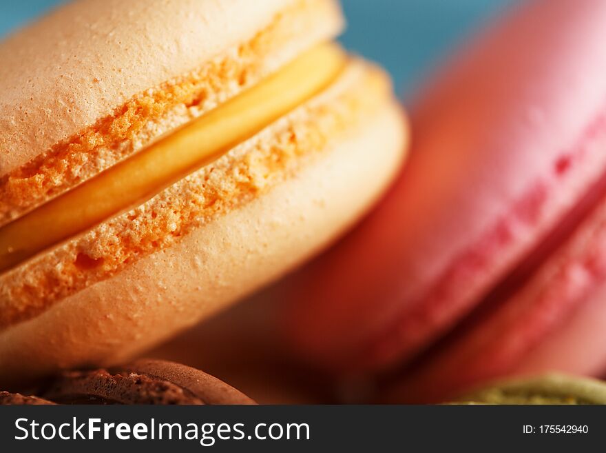 Macaron cookies with different color filling close-up, macro. French pastry made from egg whites, sugar and ground almonds. Usually made in the form of cookies, cream or jam is placed between the two layers