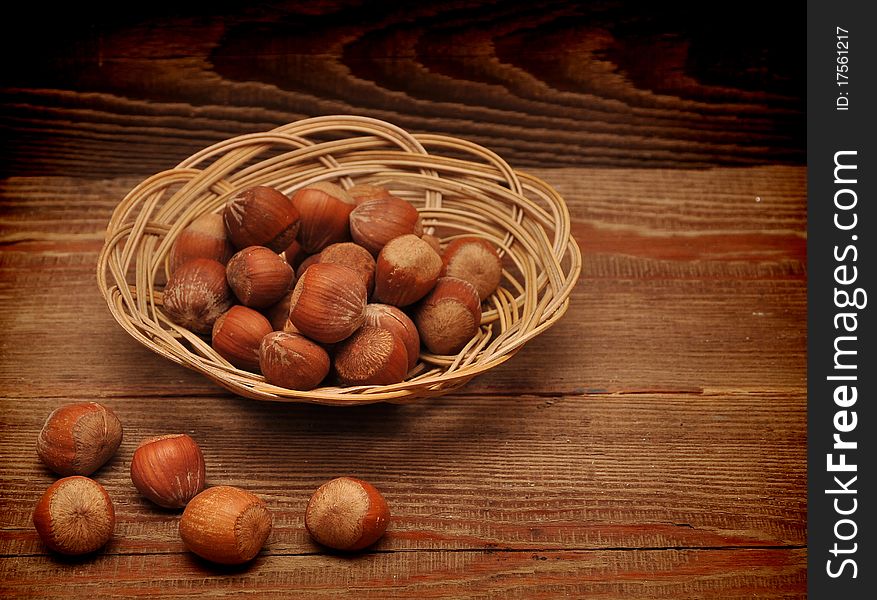 Wood nuts in a basket on wood background