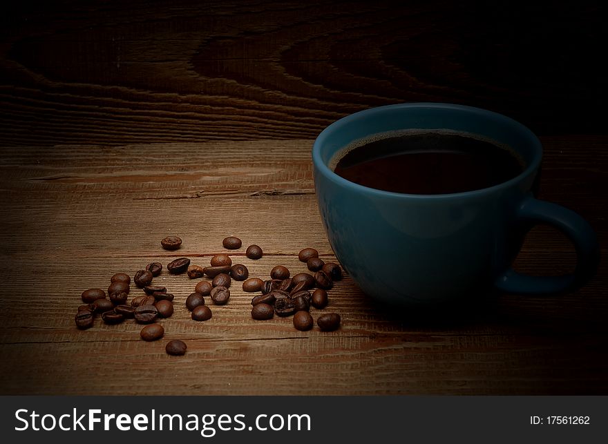 Grains and cup of coffee on wood background