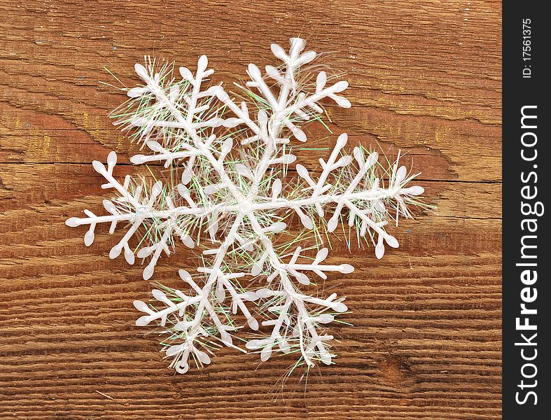 Closeup snowflake on wooden background