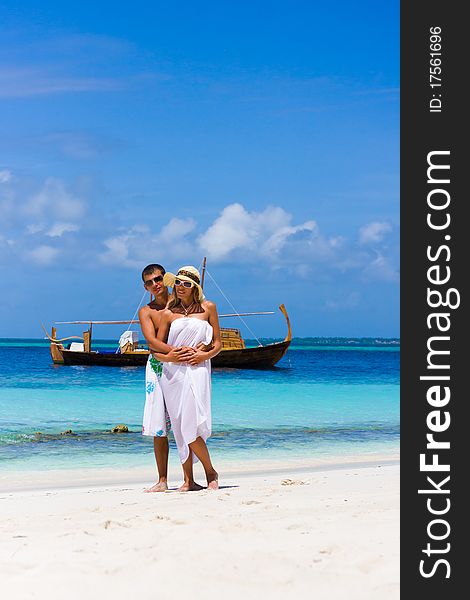 Young couple on a beach on a background a yacht