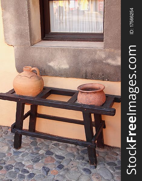 Two ceramic jugs on a bench at the house